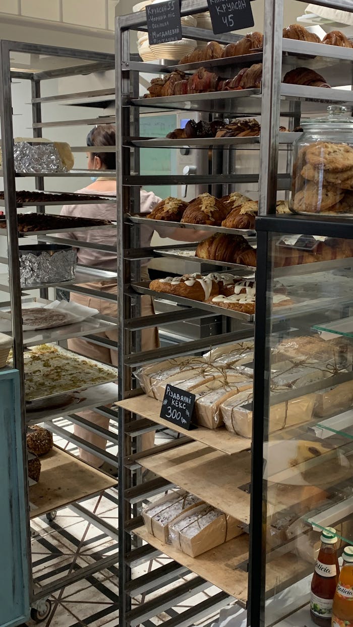 Breads and pastries on display in a Ukrainian bakery with visible price tags.